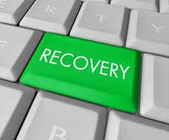 vibrant green recovery key symbolizes hope and digital resilience amidst sleek gray keyboard keys.
