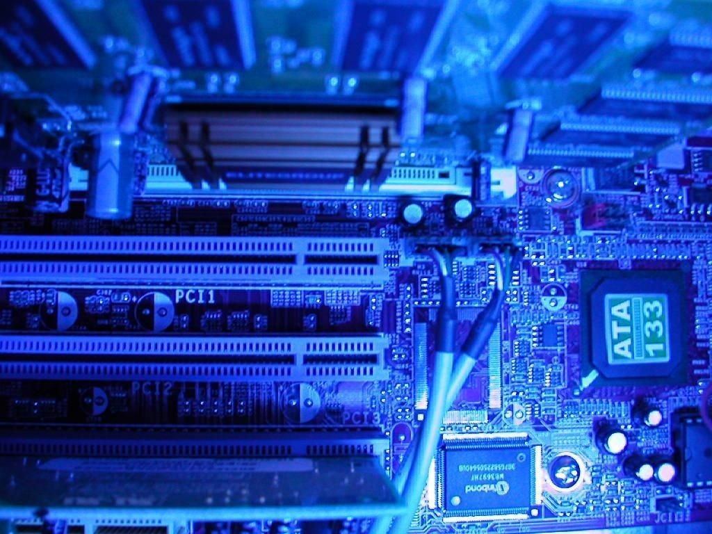 detailed close-up of a computer motherboard highlighting its blue circuitry and expansion slots.