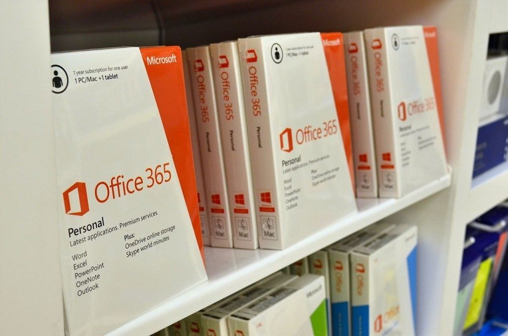 neatly arranged microsoft office 365 packages for home and personal use on a white shelf.