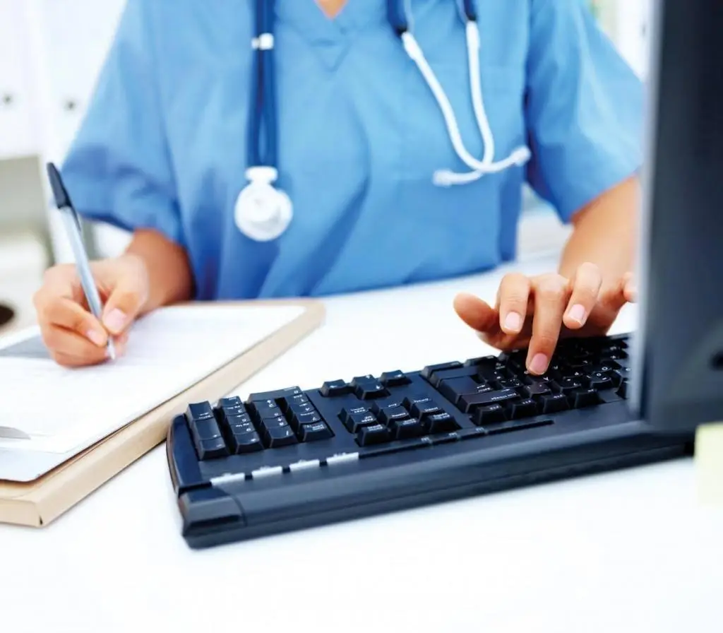 It Support For Medical Practices: Are You Prepared For Data Breaches? 3 healthcare professional in scrubs managing patient data in a bright medical setting.