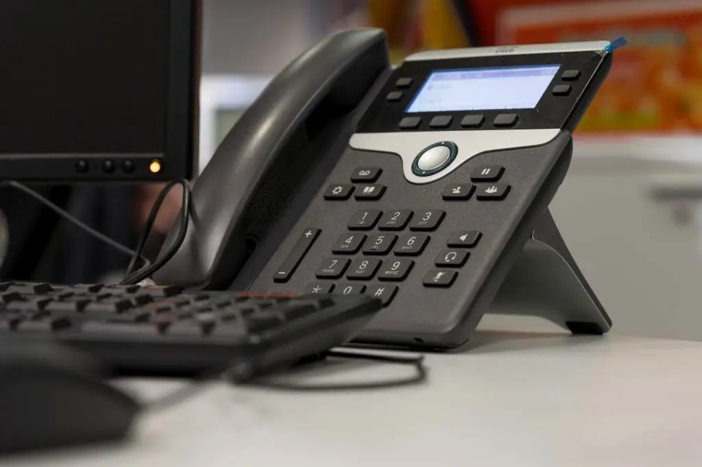 Skype For Business 3 modern office setup showcasing a sleek phone and a black keyboard for efficient communication.
