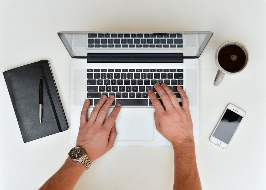 sleek workspace essentials: laptop, notebook, pen, coffee mug, and smartphone for enhanced productivity.