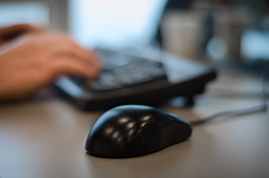 sleek black mouse and poised hand signify a modern workspace for focused productivity.