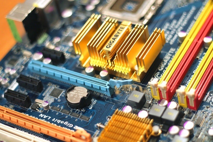 close-up of a blue motherboard with heatsinks, ram slots, and pci express for optimal performance.