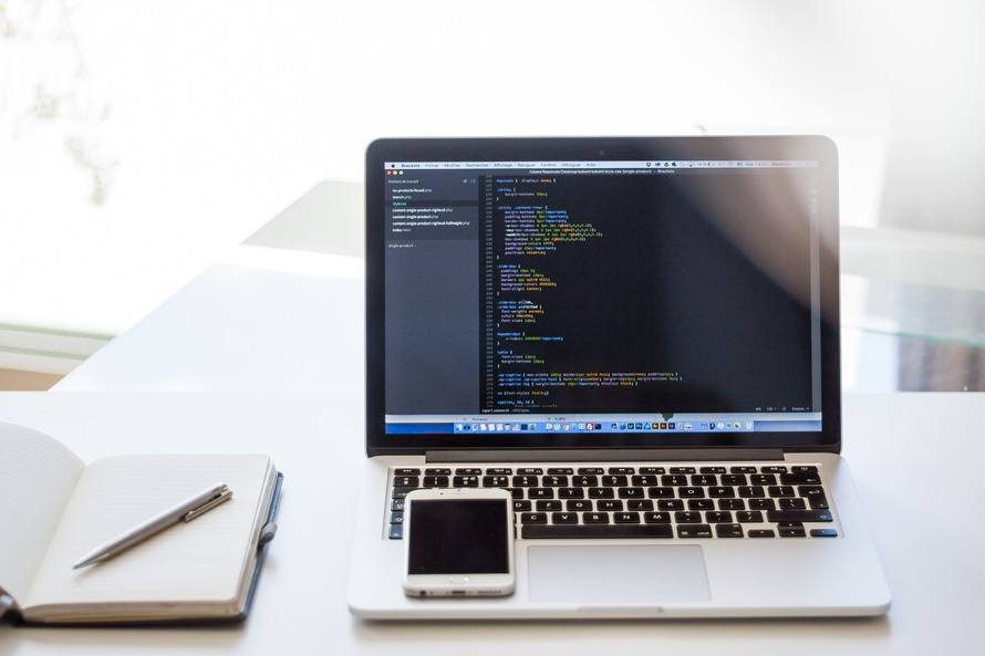 modern workspace with a macbook, smartphone, and notebook for enhanced productivity and organization.