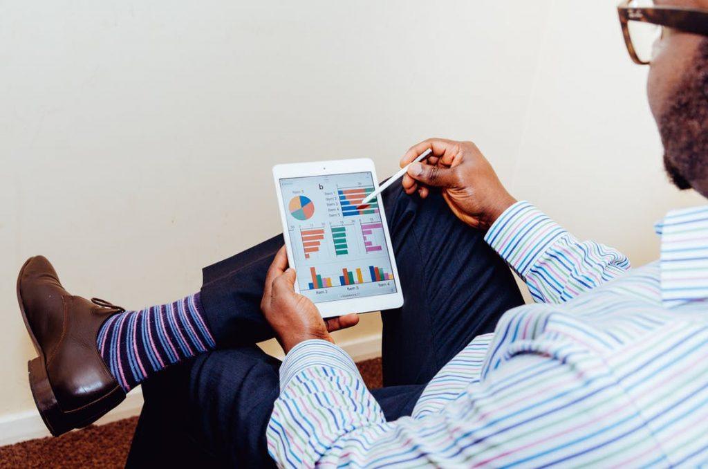 professional man analyzes data on a tablet, blending style and focus in a modern office.