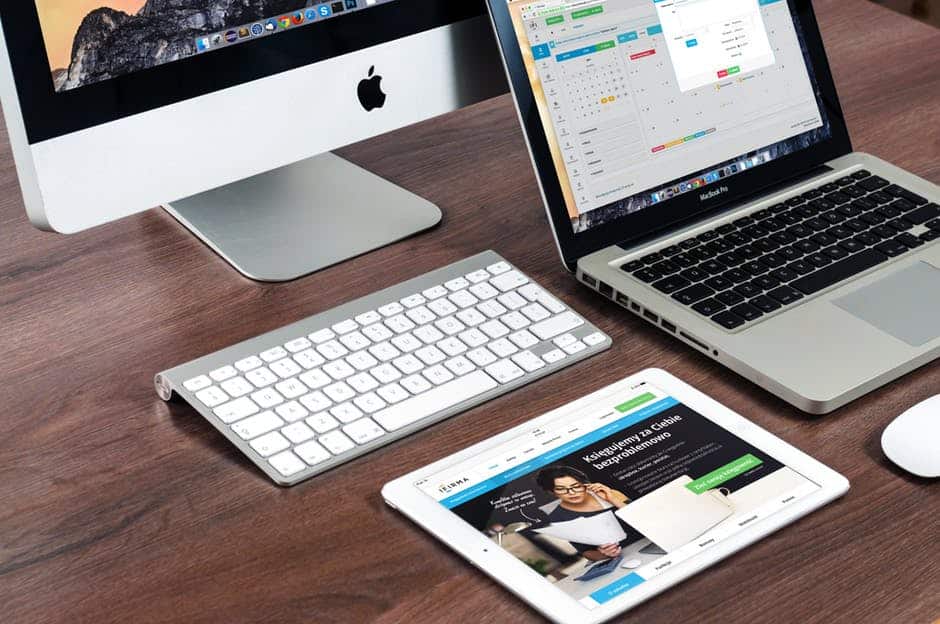 sleek apple devices on a wooden tabletop create a harmonious, modern workspace.