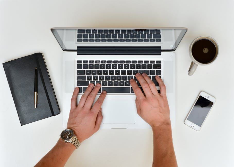 a modern workspace with a laptop, notebook, smartphone, and coffee promotes productivity and focus.