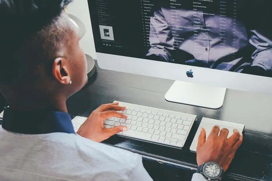professional in a modern workspace using an imac, focused on digital tasks and creativity.