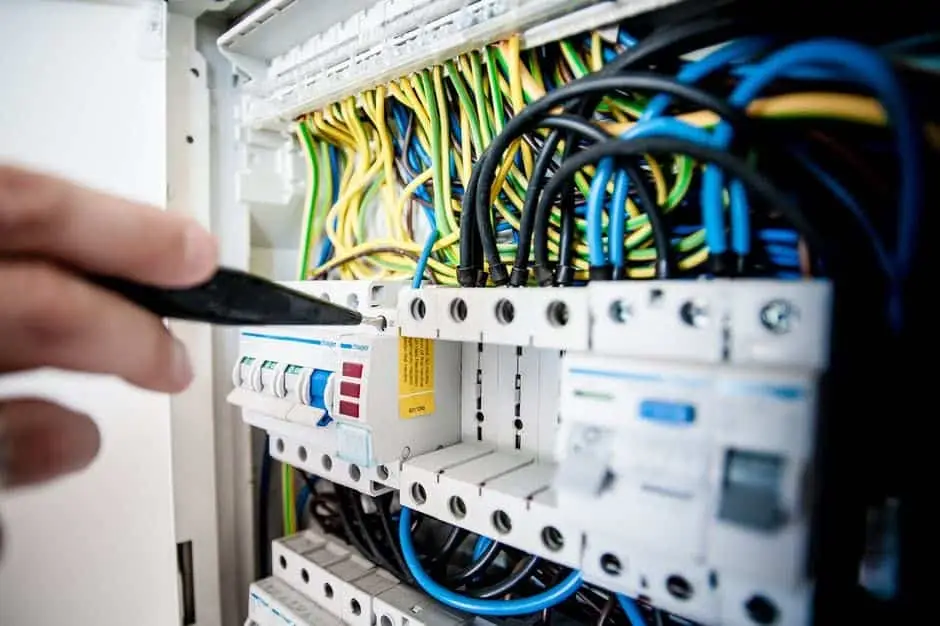 Cable Installation Is An Important Investment 6 hand adjusting circuit breakers in a well-organized electrical panel during maintenance.