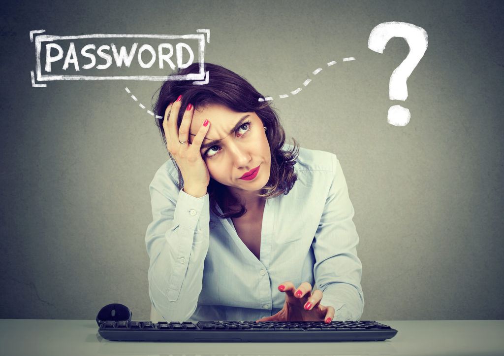 frustrated woman at computer struggling to remember her password, highlighting digital confusion.
