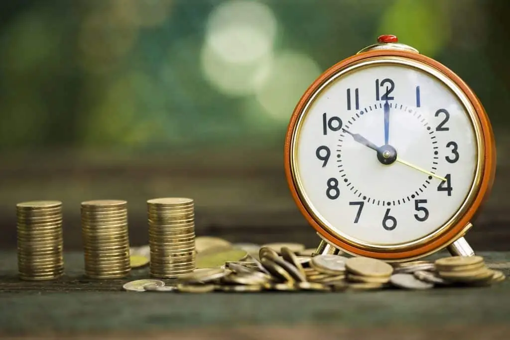 Maximizing It Service Management For Time And Cost Savings 4 vintage alarm clock surrounded by coins highlights the connection between time and money.