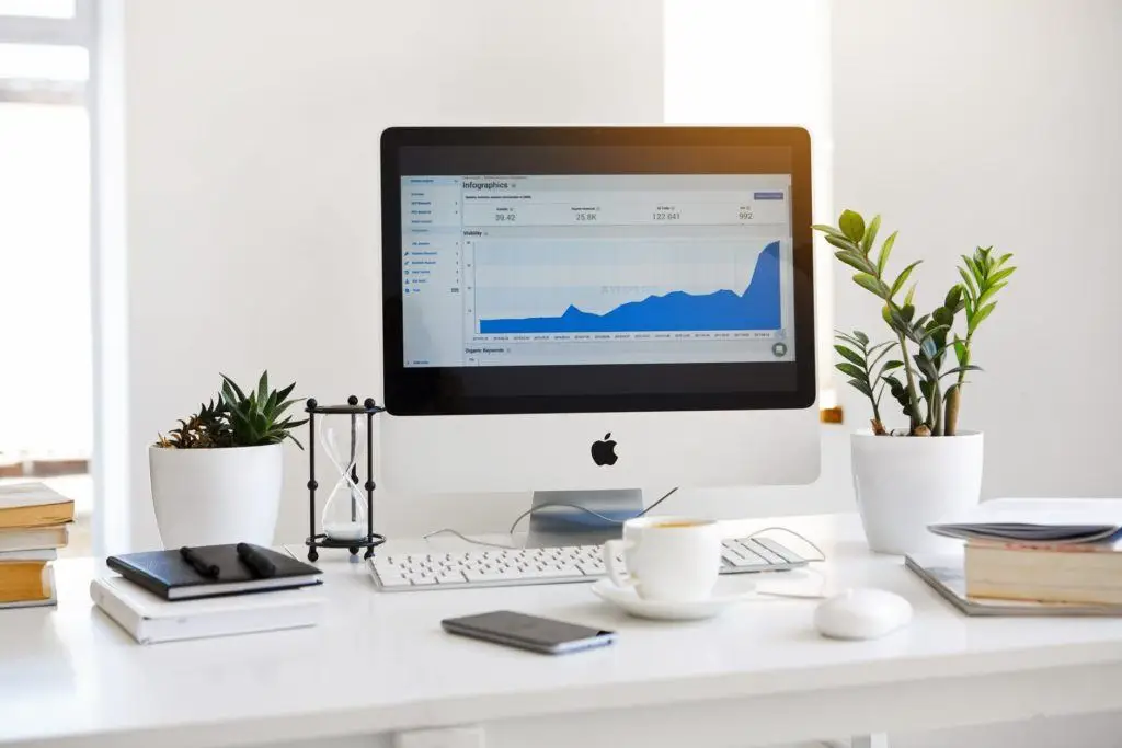 bright minimalist workspace with computer, plants, and essential tools for productivity.