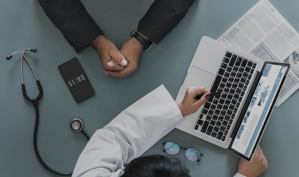 healthcare provider discusses patient information using technology in a professional medical setting.