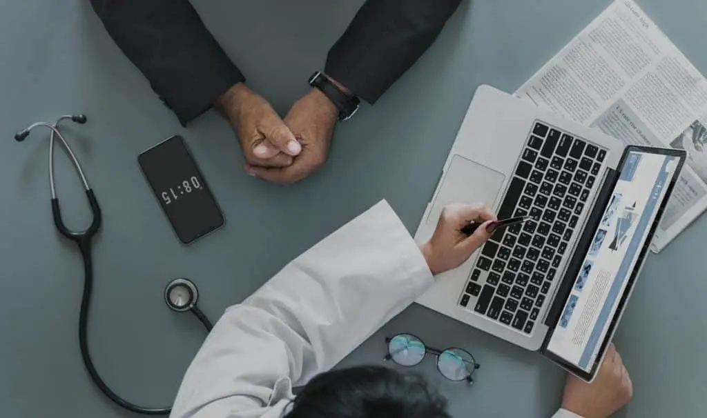 healthcare provider discusses patient information using technology in a professional medical setting.