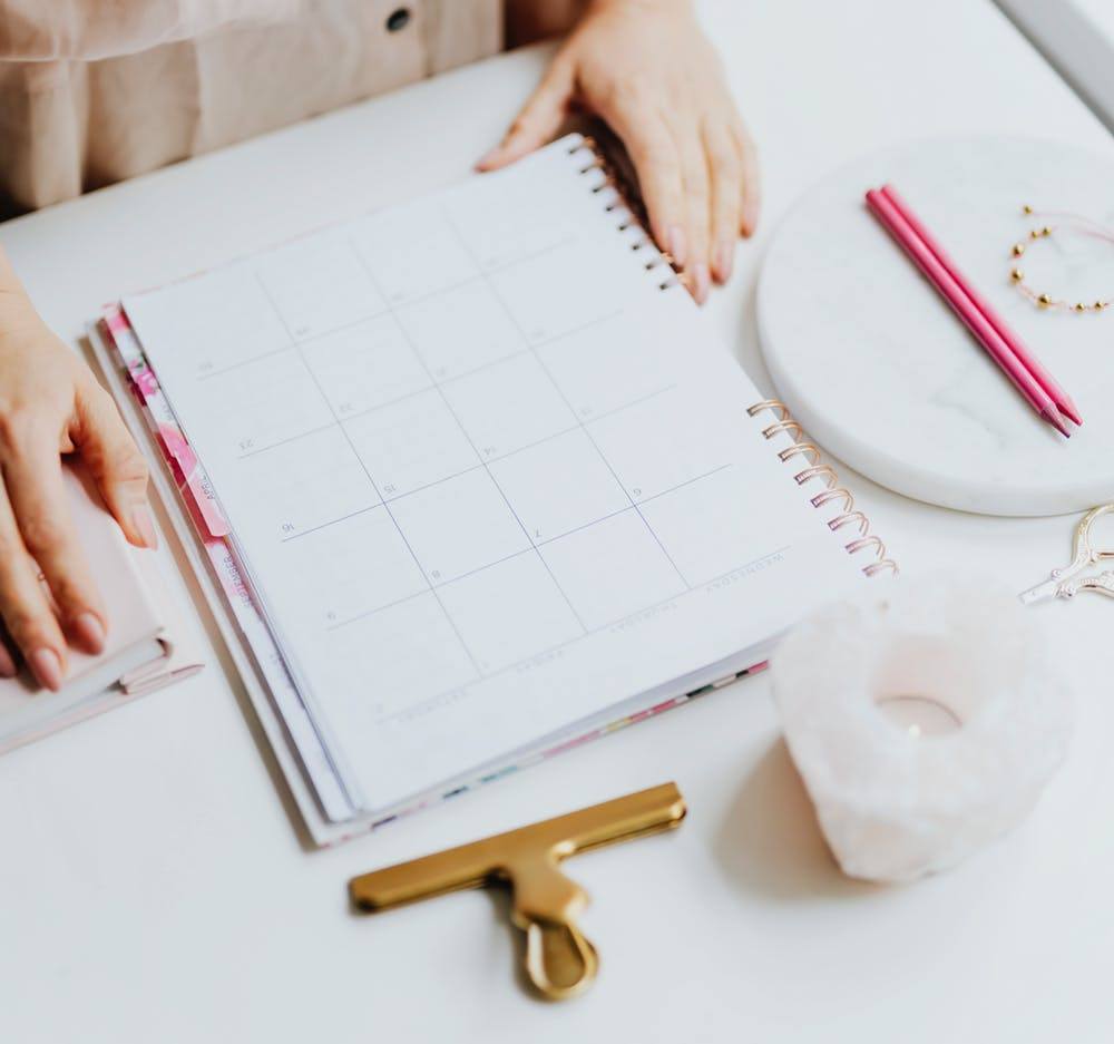 serene workspace with open planner, decorative stationery, and calming rose quartz candle holder.
