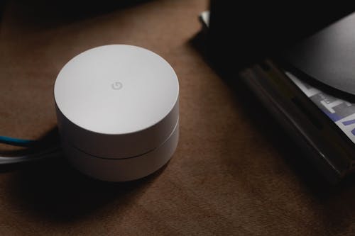 modern white wi-fi router on a wooden table, blending technology with warm home decor.