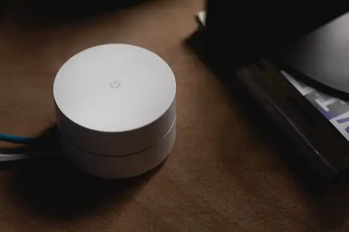 What Is Wifi 6? 3 modern white wi-fi router on a wooden table, blending technology with warm home decor.