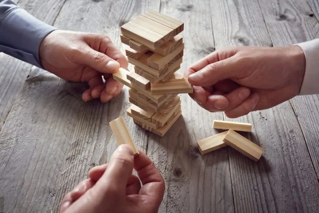 New York Cyber Security Study Is Scary 5 intense jenga game moment with friends, showcasing skillful play and a precarious tower.