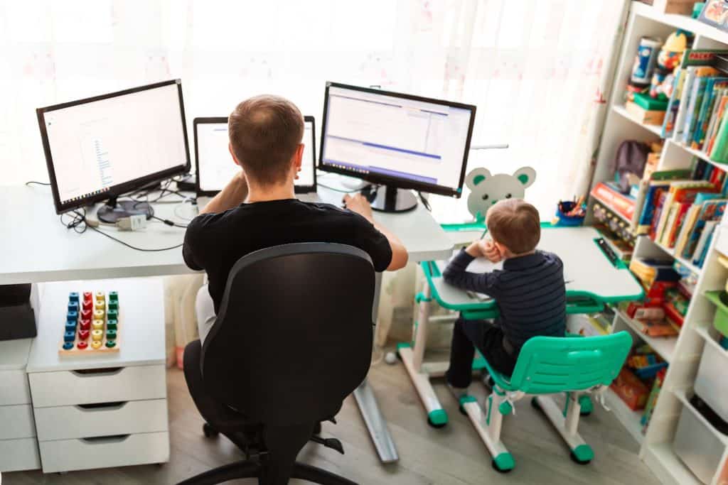 cozy workspace featuring a father working while his curious son engages nearby, promoting learning.