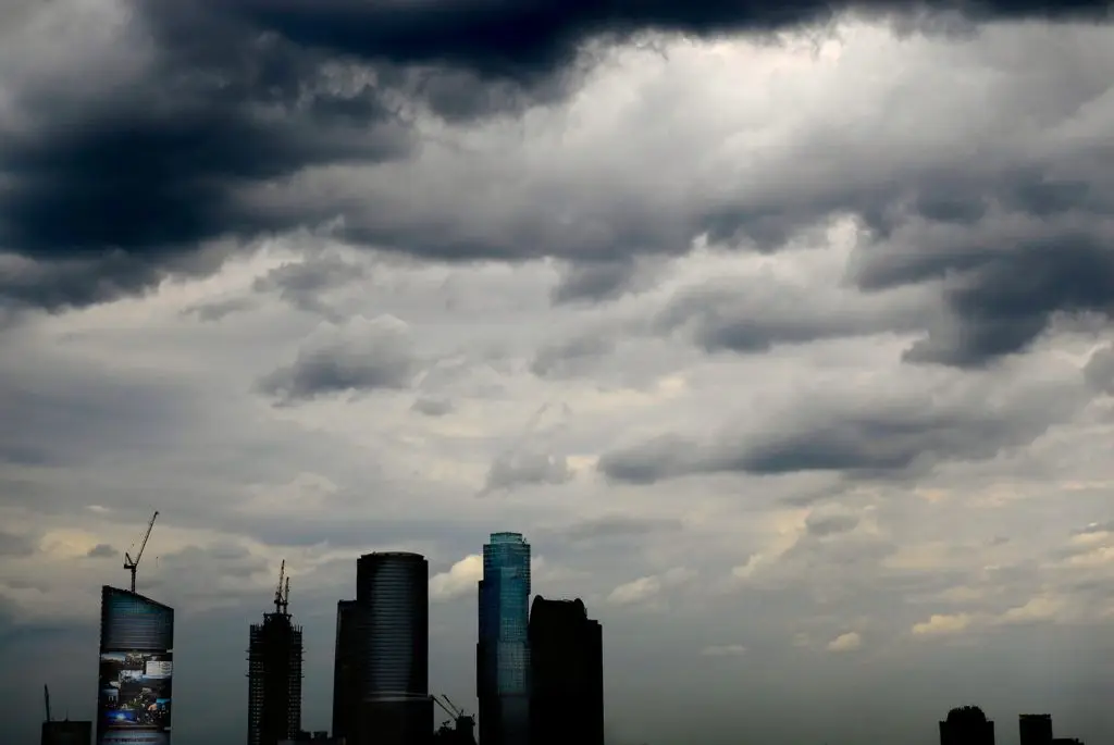 Disaster Recovery Services Every Florida Business Needs 1 urban skyline with modern skyscrapers under dramatic, stormy clouds signifies growth amid natural challenges.
