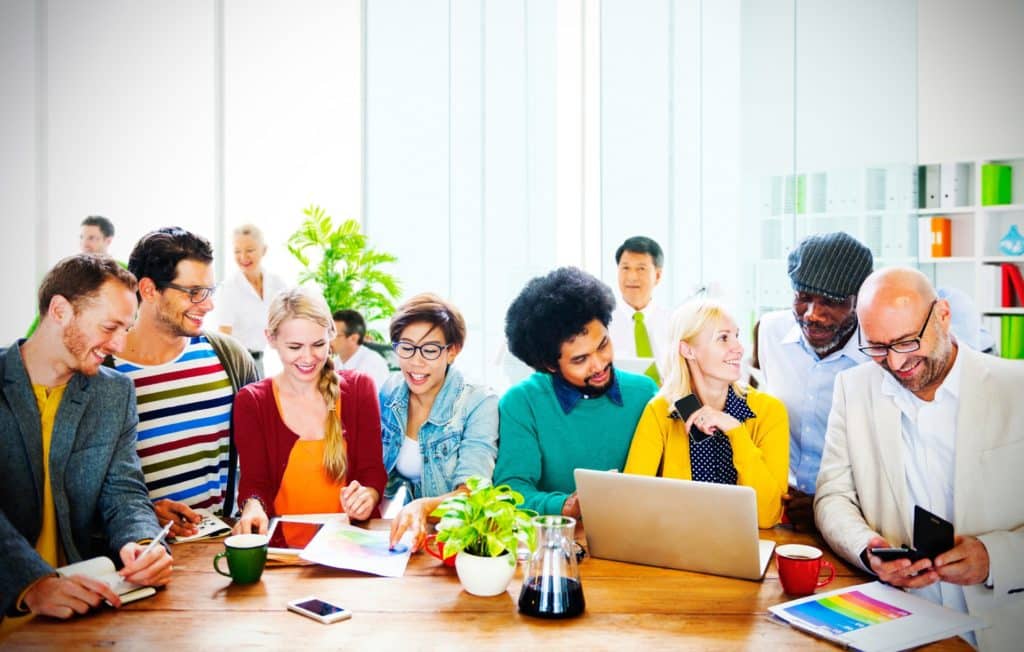 diverse team collaborating in a modern workspace, brainstorming ideas around a wooden table.