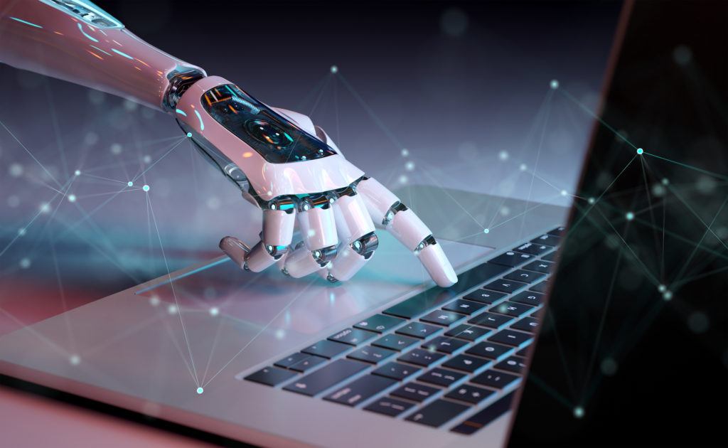 futuristic robotic hand poised above laptop keyboard, symbolizing human-machine interaction and advanced technology.