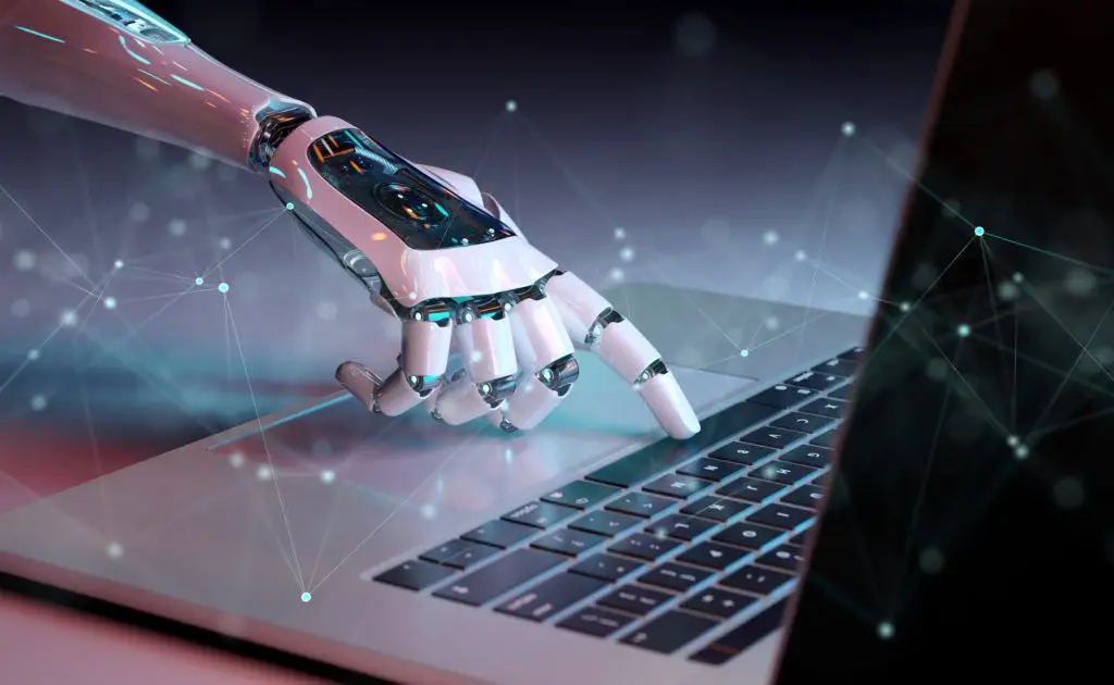 Automation Technology: Benefits And Concerns 2 futuristic robotic hand poised above laptop keyboard, symbolizing human-machine interaction and advanced technology.