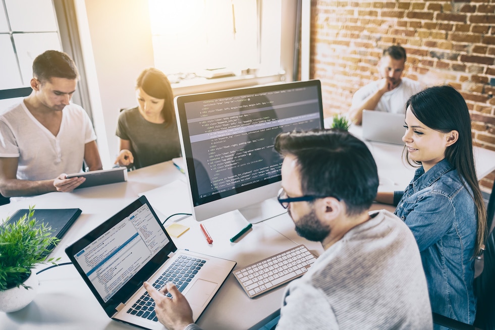 team of programmers collaborating on innovative web design in a modern office setting.