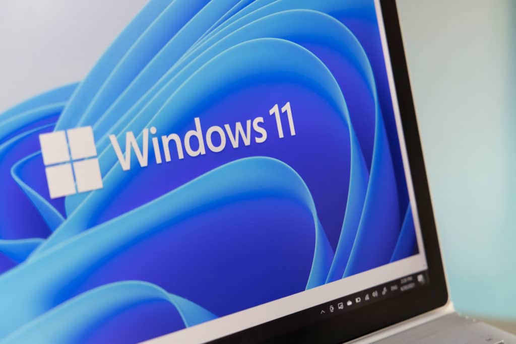 close-up of windows 11 logo on a laptop screen with a vibrant blue background.