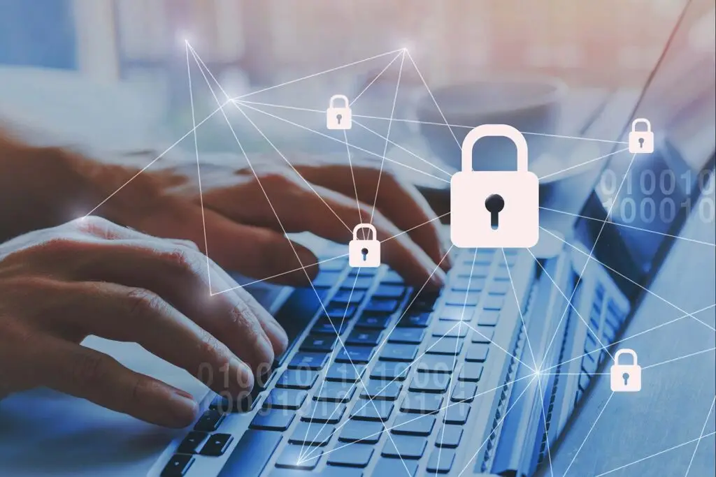 Here Are The Online Threats You Need To Be Concerned With 3 hands typing on a laptop, surrounded by digital lock icons for cybersecurity and data protection.