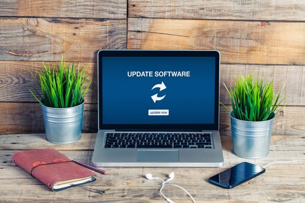 Tip Of The Week: Maintaining Software That Fits Your Business 1 modern workspace with laptop, greenery, and stylish decor, bathed in natural light.