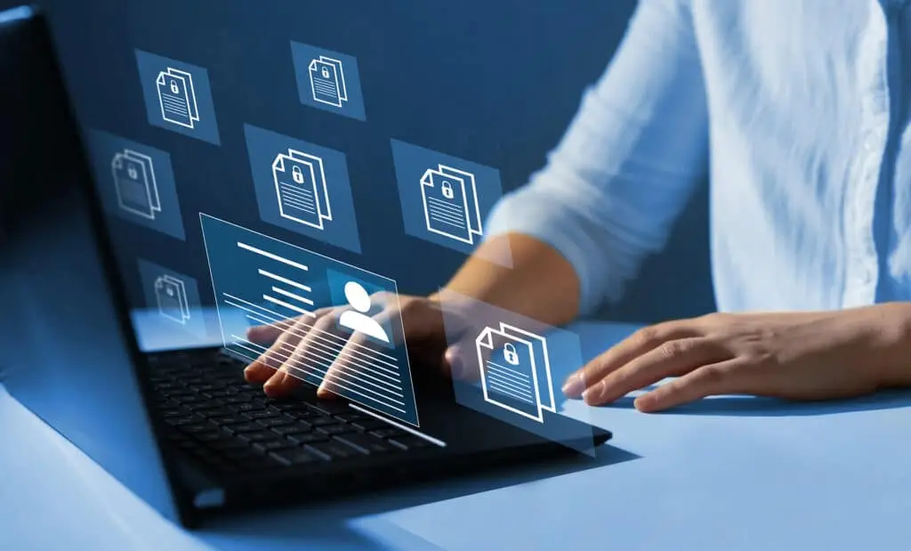 Protecting Employee Privacy Is Really Important 3 person engaged with a laptop in a high-tech workspace, surrounded by floating digital icons.