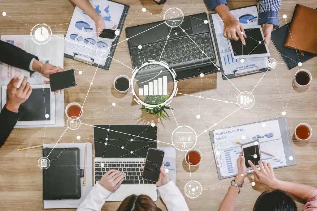 3 Tips For Choosing The Right Office Technology 3 diverse professionals collaborate on data-driven strategies using technology in a modern office meeting.