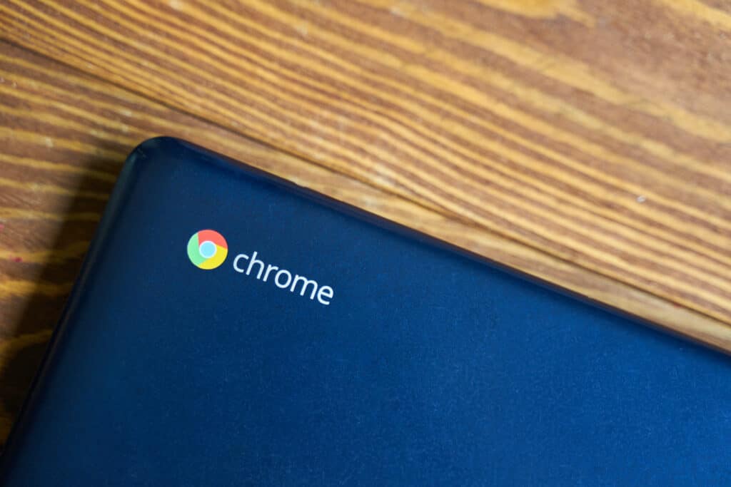 sleek blue asus chromebook on wooden table, blending modern tech with natural aesthetics.