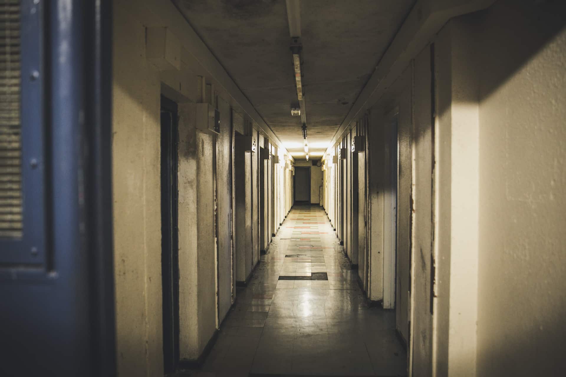 a long hallway with several doors leading to another room