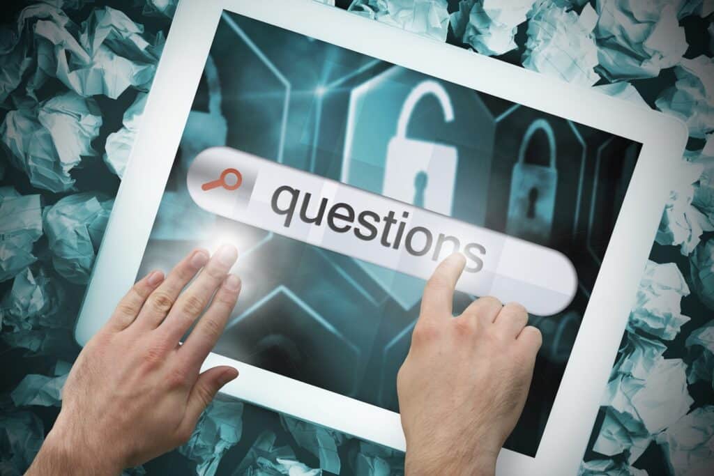 hands interacting with a tablets search bar for questions against a backdrop of crumpled paper.