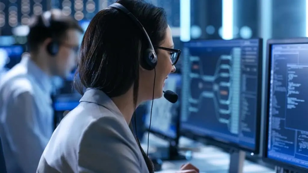 focused professional in a modern workspace analyzing dynamic data on glowing monitors.